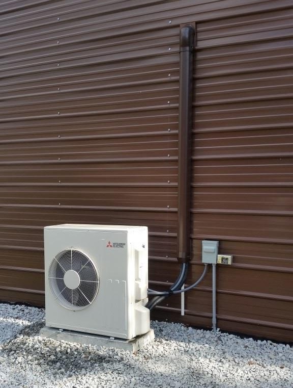 HVAC technician inspecting an outdoor AC condenser in Irmo, SC